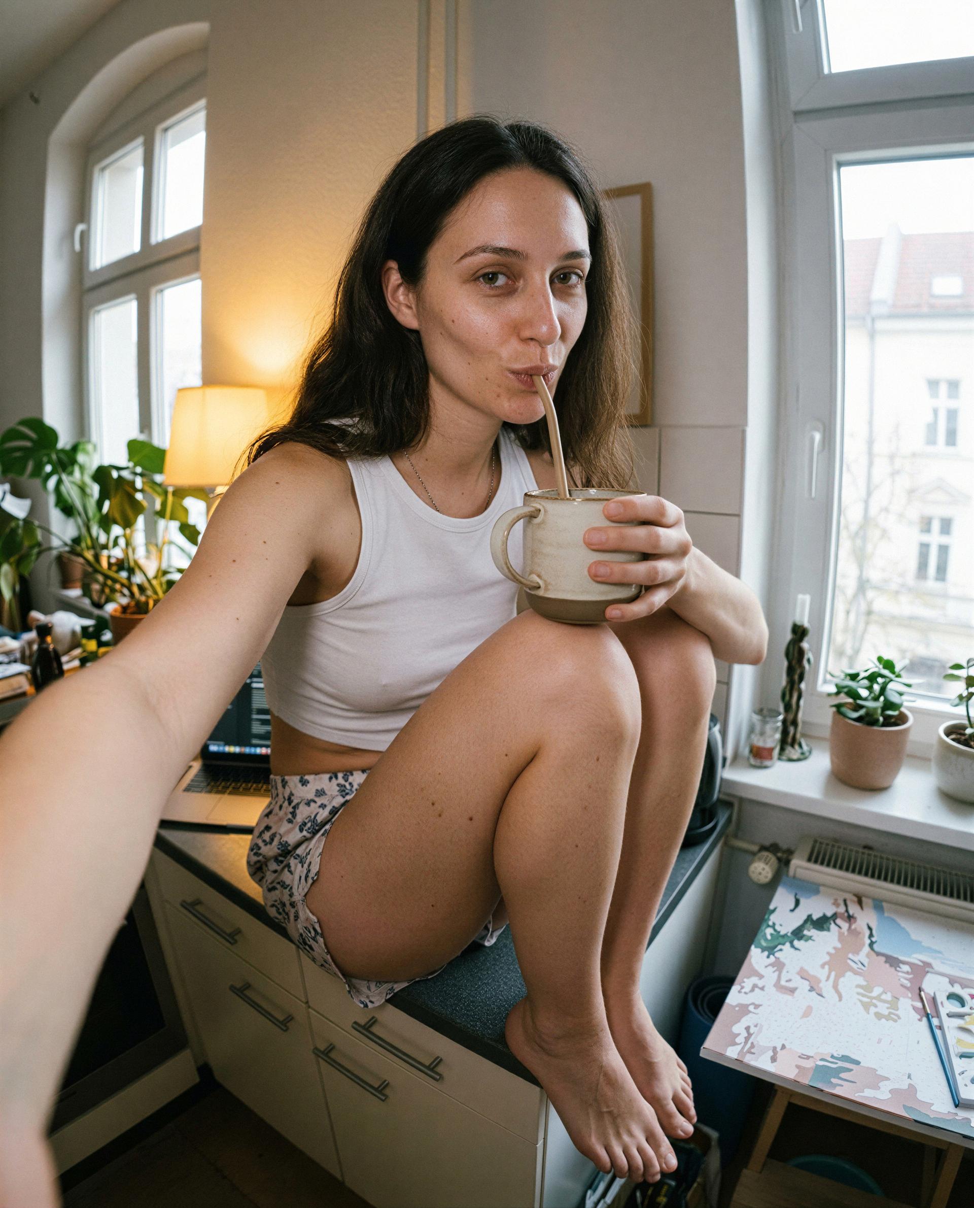 Perched on the counter with a straw in my lips - care to be the reason I don't finish my coffee? 😉, by Emily Schäfer